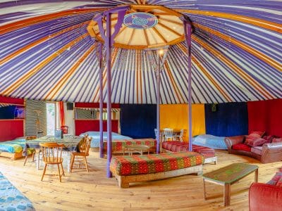 Yourte colorée en Basse-Normandie, avec un intérieur chaleureux et des lits confortables.