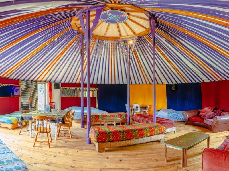 Yourte colorée en Basse-Normandie, avec un intérieur chaleureux et des lits confortables.