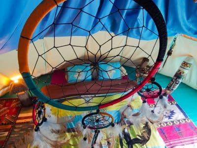 Tente berbère colorée avec un attrape-rêves et un lit douillet à Basse-Normandie.