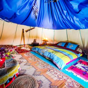 Tente berbère colorée avec lit douillet et décor chaleureux en Basse-Normandie.