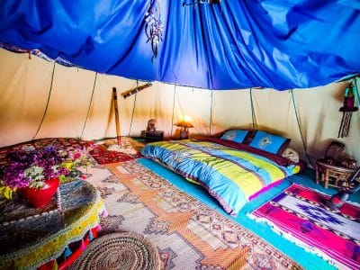Tente berbère colorée avec lit douillet et décor chaleureux en Basse-Normandie.