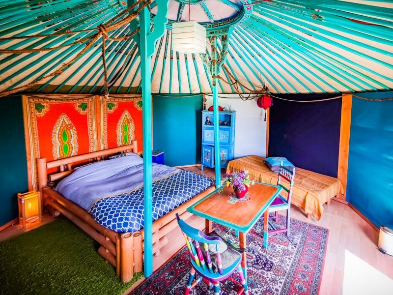 Yourte colorée en Basse-Normandie, avec lit douillet et décor chaleureux.