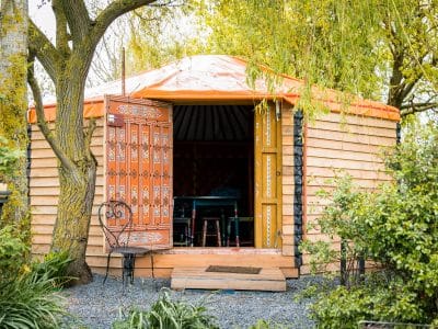 Yourte colorée en Basse-Normandie, entourée de verdure et dun jardin paisible.