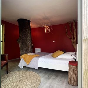 Hébergement insolite en Bourgogne : chambre avec un tronc darbre et décor chaleureux.