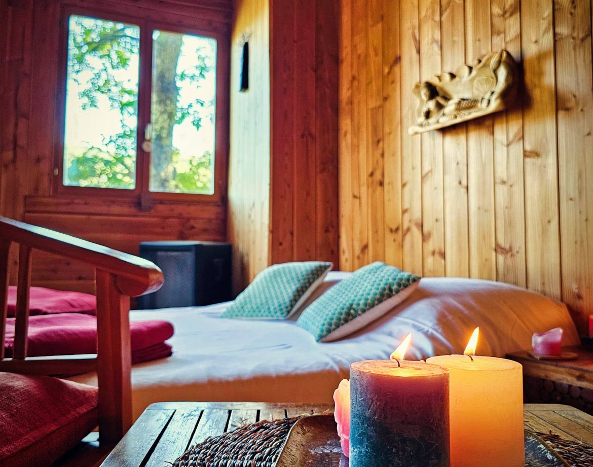 Chalet en bois chaleureux à Limousin, avec bougies et vue sur la nature.