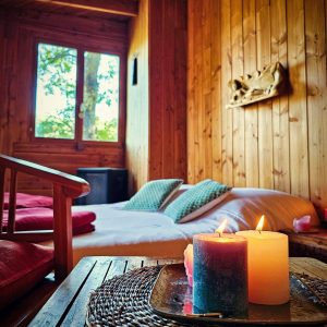 Chalet en bois chaleureux à Limousin, avec bougies et vue sur la nature.