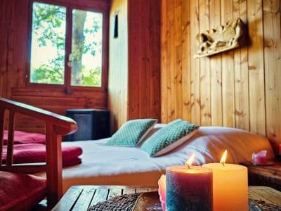 Chalet en bois chaleureux à Limousin, avec bougies et vue sur la nature.
