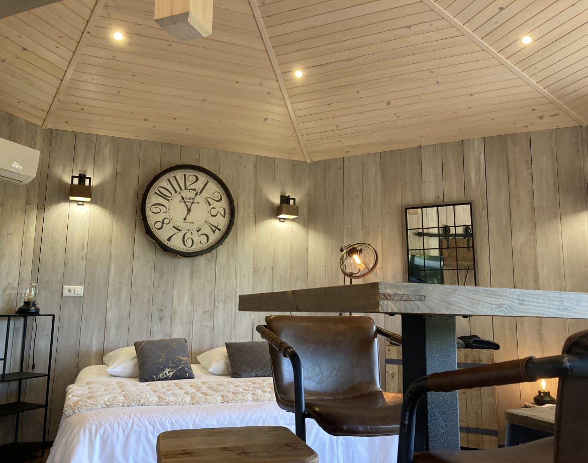 Hébergement insolite en bois à Languedoc-Roussillon, avec un grand horloge murale.