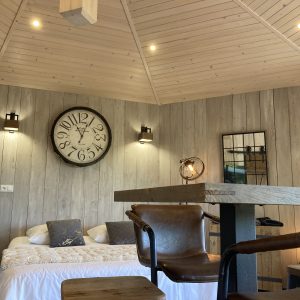 Hébergement insolite en bois à Languedoc-Roussillon, avec un grand horloge murale.