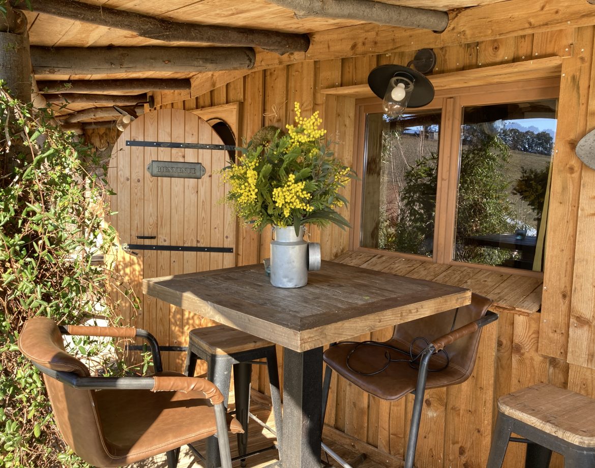 Cabane en bois à Languedoc-Roussillon avec table en bois et fleurs décoratives.