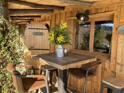 Cabane en bois à Languedoc-Roussillon avec table en bois et fleurs décoratives.