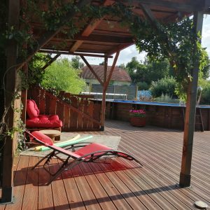 Hébergement insolite en Midi-Pyrénées : terrasse en bois avec fauteuils confortables.