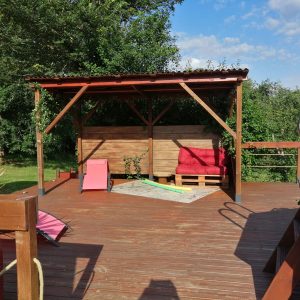 Hébergement insolite en Midi-Pyrénées : terrasse en bois avec transats colorés et ombre.