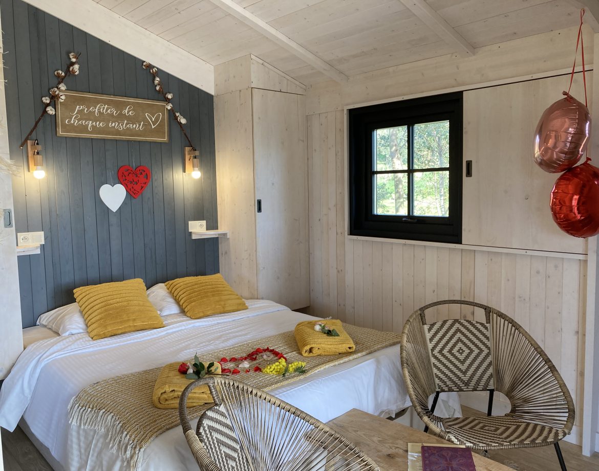 Cabane romantique en bois avec lit douillet et décoration chaleureuse.