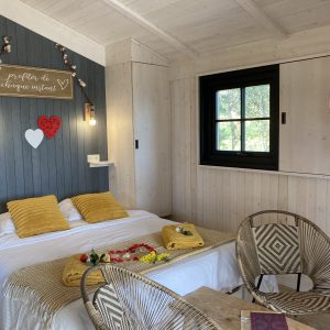 Cabane romantique en bois avec lit douillet et décoration chaleureuse.