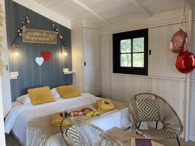 Cabane romantique en bois avec lit douillet et décoration chaleureuse.
