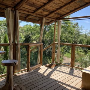 Cabane perchée en bois avec vue sur la nature verdoyante du Languedoc-Roussillon.