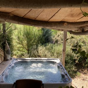 Hébergement insolite en Languedoc-Roussillon avec jacuzzi sous un toit en bois naturel.