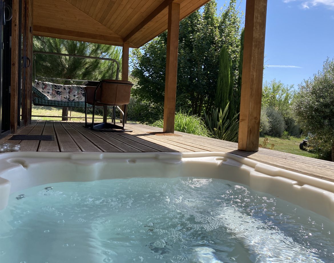 Hébergement insolite en Languedoc-Roussillon avec jacuzzi et terrasse en bois.