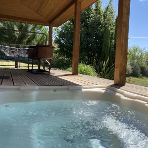 Hébergement insolite en Languedoc-Roussillon avec jacuzzi et terrasse en bois.