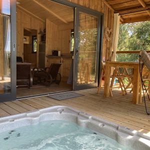 Cabane en bois avec jacuzzi sur la terrasse, vue sur la nature en Languedoc-Roussillon.