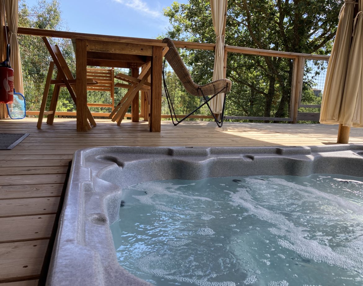Cabane perchée en Languedoc-Roussillon avec jacuzzi et terrasse en bois.