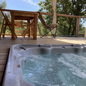 Cabane perchée en Languedoc-Roussillon avec jacuzzi et terrasse en bois.