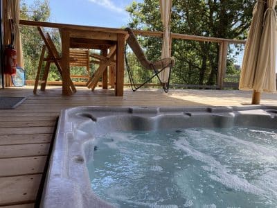 Cabane perchée en Languedoc-Roussillon avec jacuzzi et terrasse en bois.