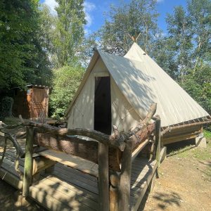 Tente safari en pleine nature, entourée darbres verdoyants à Basse-Normandie.