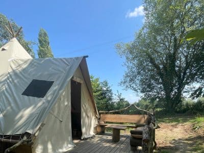 Tente safari en Basse-Normandie, avec terrasse en bois et vue sur la nature.