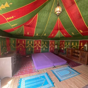 Tente berbère colorée avec tapis et matelas, hébergement insolite en Basse-Normandie.