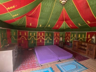 Tente berbère colorée avec tapis et matelas, hébergement insolite en Basse-Normandie.