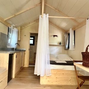 Cabane moderne en bois, avec lit confortable et cuisine ouverte, au cœur de lAuvergne.