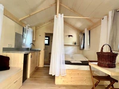 Cabane moderne en bois, avec lit confortable et cuisine ouverte, au cœur de lAuvergne.