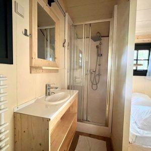 Cabane moderne en bois avec salle de bain, lumineuse et chaleureuse.