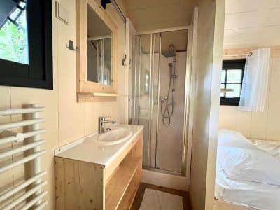 Cabane moderne en bois avec salle de bain, lumineuse et chaleureuse.