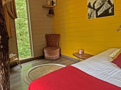 Chambre insolite en Bourgogne, murs jaunes et vue sur la nature depuis la fenêtre.