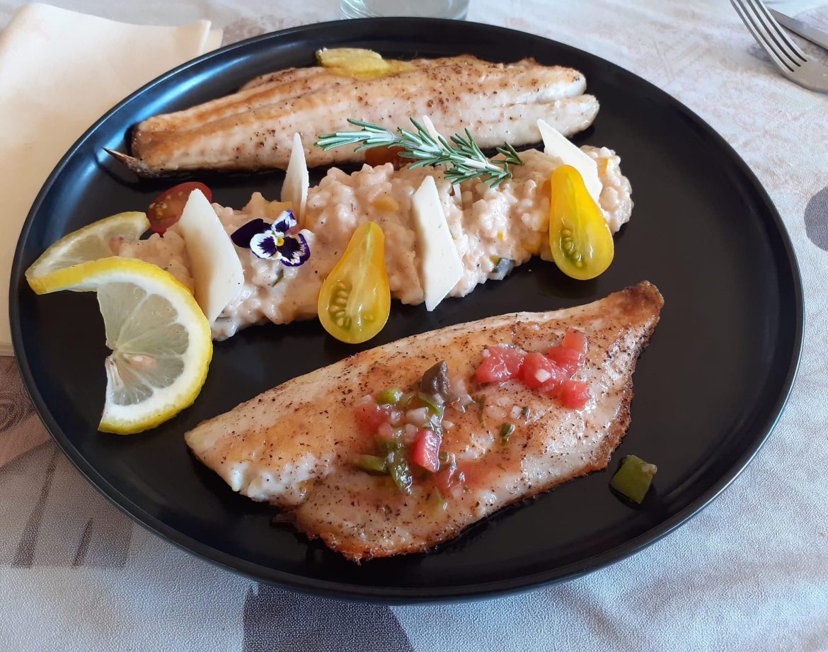Plat de poisson frais avec garniture colorée, servi dans un hébergement insolite en