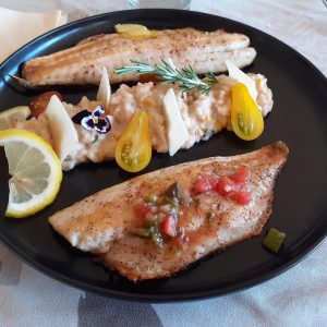 Plat de poisson frais avec garniture colorée, servi dans un hébergement insolite en