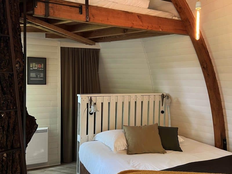 Chalet moderne avec mezzanine, lit douillet et décoration en bois chaleureux.