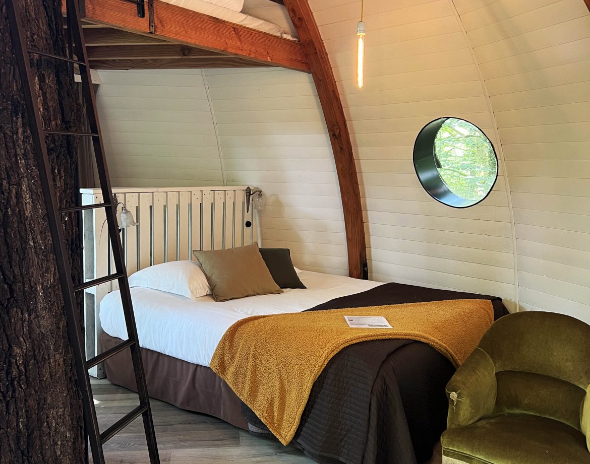 Hébergement insolite en Bourgogne : cabane ronde avec lit en mezzanine et décor chaleureux.