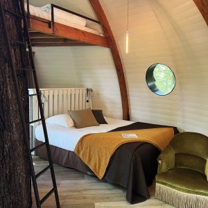 Hébergement insolite en Bourgogne : cabane ronde avec lit en mezzanine et décor chaleureux.
