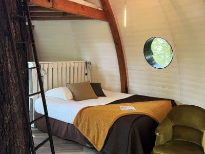 Hébergement insolite en Bourgogne : cabane ronde avec lit en mezzanine et décor chaleureux.