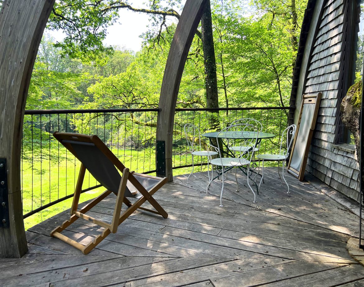 Hébergement insolite en Bourgogne : terrasse en bois avec vue sur la nature verdoyante.