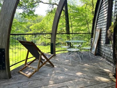 Hébergement insolite en Bourgogne : terrasse en bois avec vue sur la nature verdoyante.