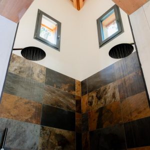 Douche spacieuse en pierre dans un hébergement insolite en Midi-Pyrénées.