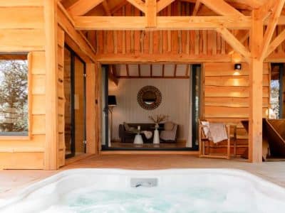 Cabane en bois avec jacuzzi, offrant une vue sur un intérieur chaleureux et moderne.