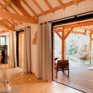Hébergement insolite en Midi-Pyrénées : cabane en bois avec terrasse et hamac.