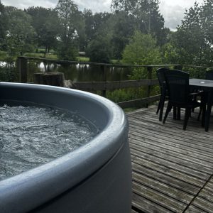 Hébergement insolite en Pays de la Loire avec jacuzzi et vue sur le lac verdoyant.