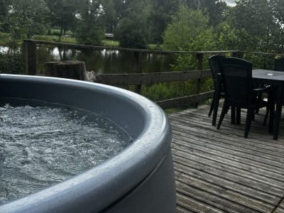 Hébergement insolite en Pays de la Loire avec jacuzzi et vue sur le lac verdoyant.